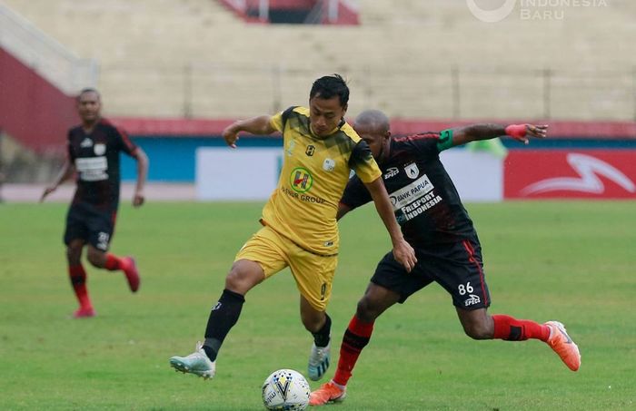 Pemain Persipura Jayapura, Boaz Solossa (kanan), saat berduel dengan pemain Barito Putera, Samsul Arif, dalam laga pekan ke-33 di Stadion Gelora Delta, Sidoarjo, Senin (16/12/2019).