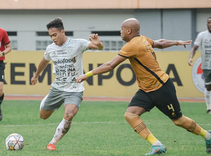 Pemain Bhayangkara FC Anderson Salles, membayang-bayangi gelandang Bali United I Made Tito pada laga pekan ke-30 Liga 1 2022/2023.