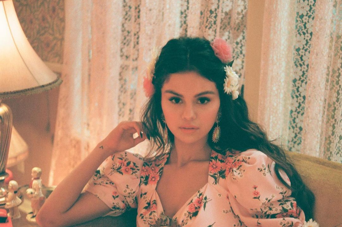Selena Gomez tampil dengan dress bermotif bunga.
