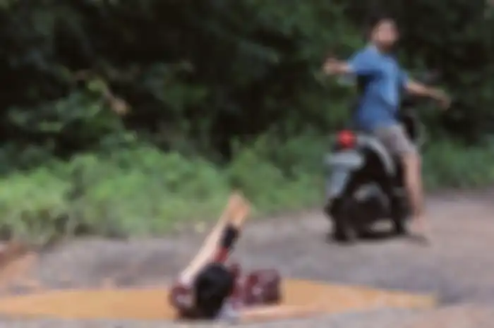 Ilustrasi naik motor di jalan rusak, pembonceng sampai terjatuh.