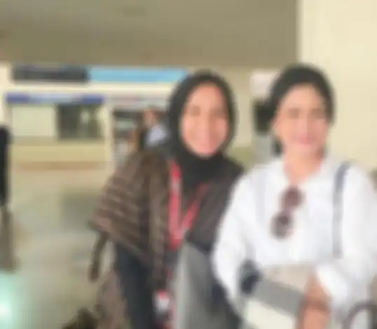 Nadya Arifta yang mengenakan pakaian garis-garis berwarna cokelat dan hitam juga dilengkapi kerudung berwarna senada pun tampak berdiri di samping istri Presiden Joko Widodo.
