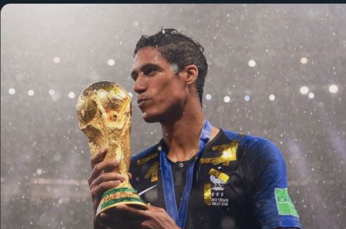 Raphael Varane mencium trofi Piala Dunia 2018 setelah juara bersama timnas Prancis.