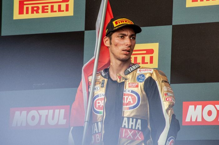 Pembalap Pata Yamaha asal Turki, Toprak Razgatlioglu berdiri di podium usai meraih gelar juara dunia WSBK 2021 di Sirkuit Mandalika, Lombok, Indonesia, Minggu (21/11/2021)