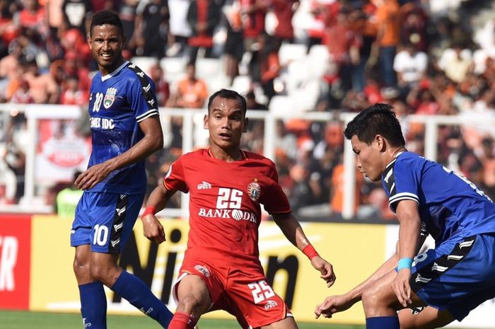 Pemain Persija Jakarta Riko Simanjutkan ketika di hadang pemain Becamex Binh Duong dalam laga penyisihan Grup G Piala AFC 2019, Selasa (26/2/2019) di Stadion Gelora Bung Karno, Jakarta.