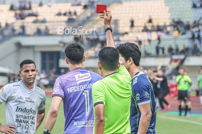 Wasit yang memimpin laga pekan kelima Liga 1 2022 antara Persib Bandung versus Bali United, M. Erfan Efendi (kanan), memberikan kartu merah kepada Nadeo Argawinata (jersey ungu)