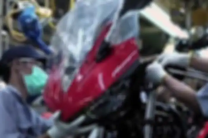 Iustrasi UMP 2022 naik. Pekerja sedang merakit motor pabrik