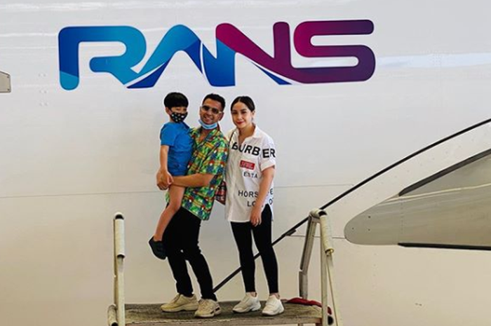 Raffi Ahmad dan Nagita Slavina berpose di depan logo Rans yang tertempel di lambung pesawat.