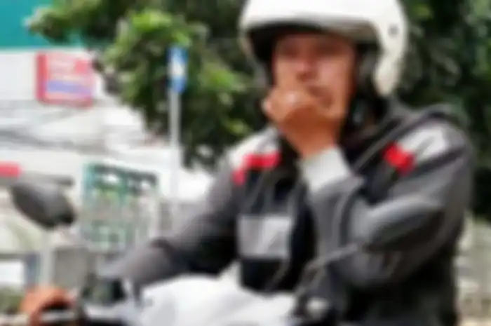 Ilustrasi pengendara motor merokok di jalan raya.