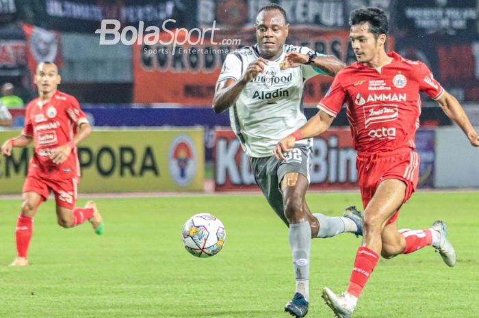 Victor Igbonedo berduel dengan Aji Kusuma pada laga Persib vs Persija di Stadion Patriot, Jumat (31/3/2023).