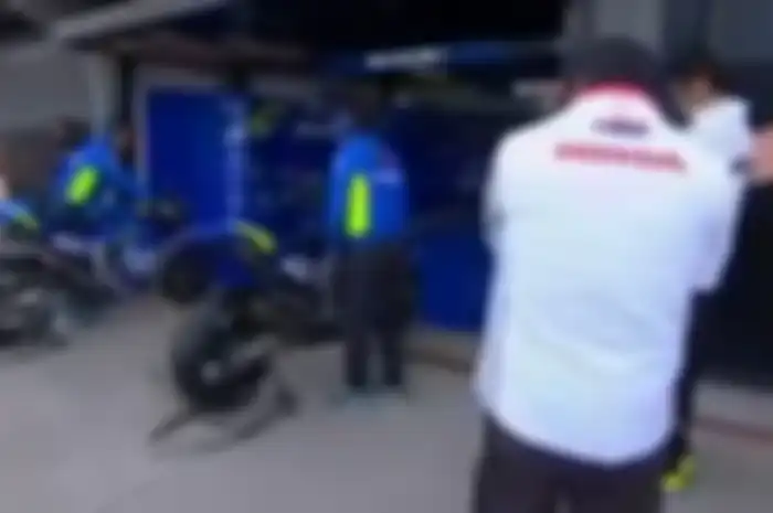 Dua mekanik Honda memperhatikan secara rinci perkembangan motor tim Suzuki Ecstar.