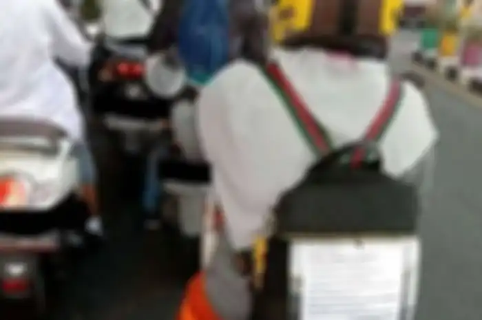 Pemotor menghimbau agar merokok jangan sambil naik motor karena berbahaya.