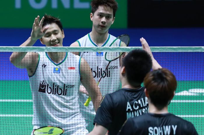 Pasangan ganda putra Indonesia, Marcus Fernaldi Gideon/Kevin Sanjaya Sukamuljo, bersalaman dengan Aaron Chia/Sooh Woi Yik (Malaysia) pada perempat final All England Open 2020 di Arena Birmingham, Inggris, Jumat (13/3/2020).