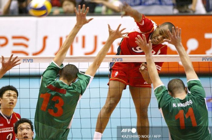 Spiker timnas voli Jepang Marcos Sugiyama (9), melakukan spike melewati pemain bertahan Aljazair, Nassim Hedroug (11), Nassim Bouchouareb (13) pada pertandingan kualifikasi Asia untuk Olimpiade Athena di Tokyo, Jepang, 22 Mei 2004. 