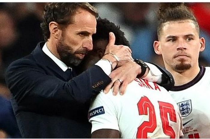 Pelatih timnas Inggris, Gareth Southgate, memeluk Bukayo Saka seusai laga final EURO 2020 kontra timnas Italia di Stadion Wembley, Minggu (11/7/2021).