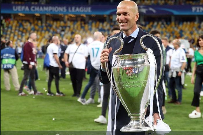 Pelatih Real Madrid, Zinedine Zidane, memegangi trofi juara Liga Champions.