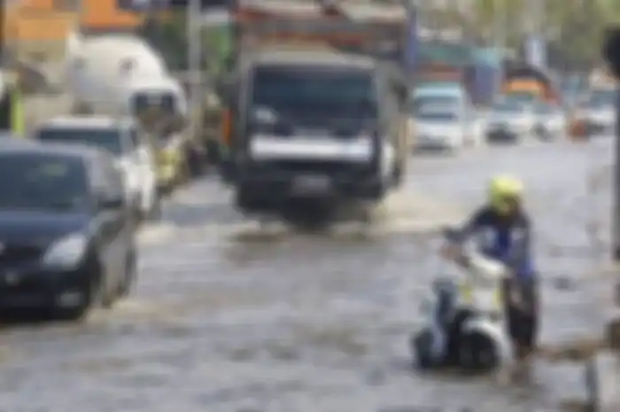 Ilustrasi pengendara motor melibas banjir dan motornya mogok.