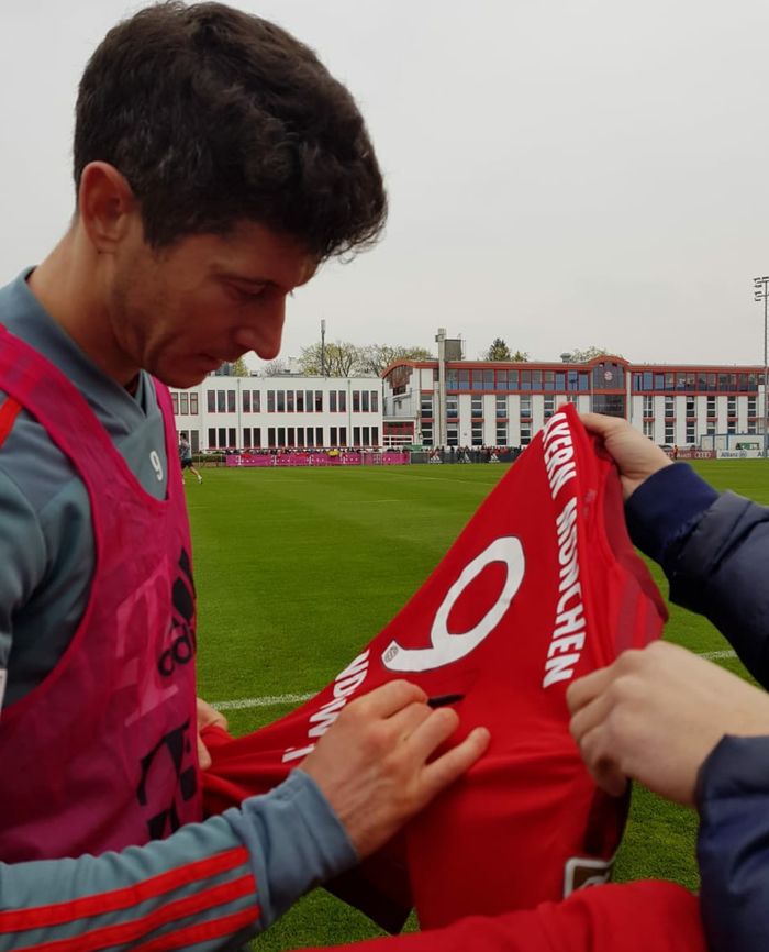 Striker FC Bayern, Robert Lewandowski, menanda tangani jersey klub untuk para fans di sesi latihan terbuka tim.