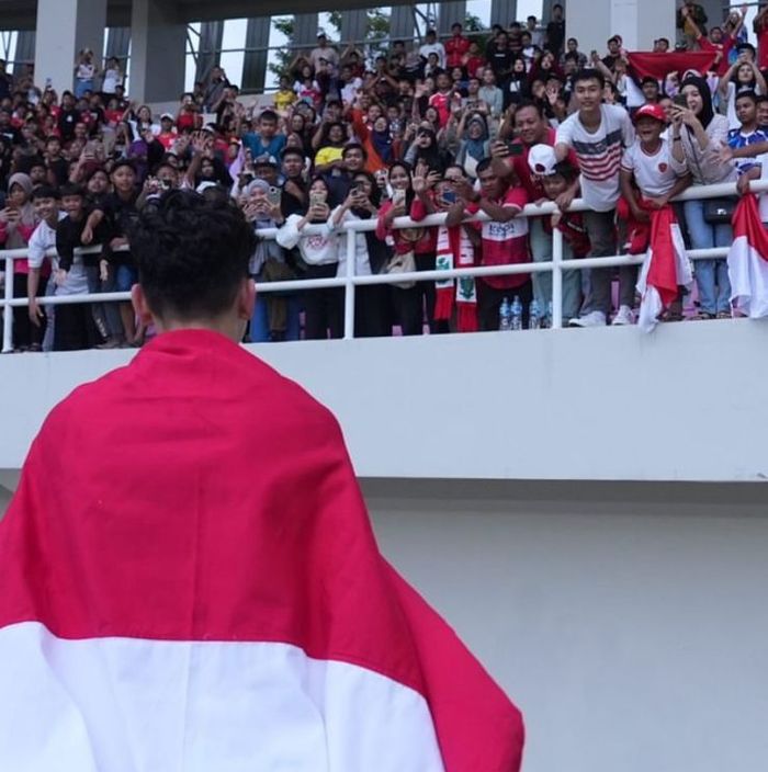 Pemain timnas U-16 Indonesia, Matthew Baker, memegang bendera Indonesia