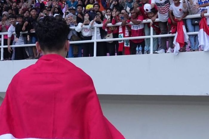 Pemain timnas U-16 Indonesia, Matthew Baker, memegang bendera Indonesia