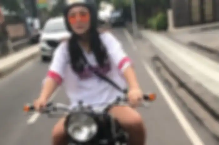Ilustrasi cewek naik motor di jalan raya.