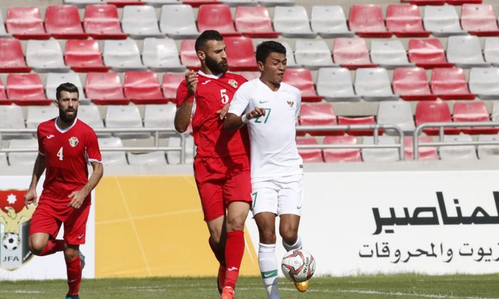 Penyerang timnas Indonesia, Dedik Setiawan dijaga ketat oleh pemain timnas Yordania, Yazan Alarab, di Stadion King Abdullah II, Amman, Yordania, Selasa (11/6/2019).