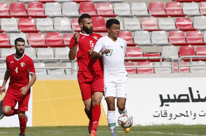 Penyerang timnas Indonesia, Dedik Setiawan dijaga ketat oleh pemain timnas Yordania, Yazan Alarab, di Stadion King Abdullah II, Amman, Yordania, Selasa (11/6/2019).