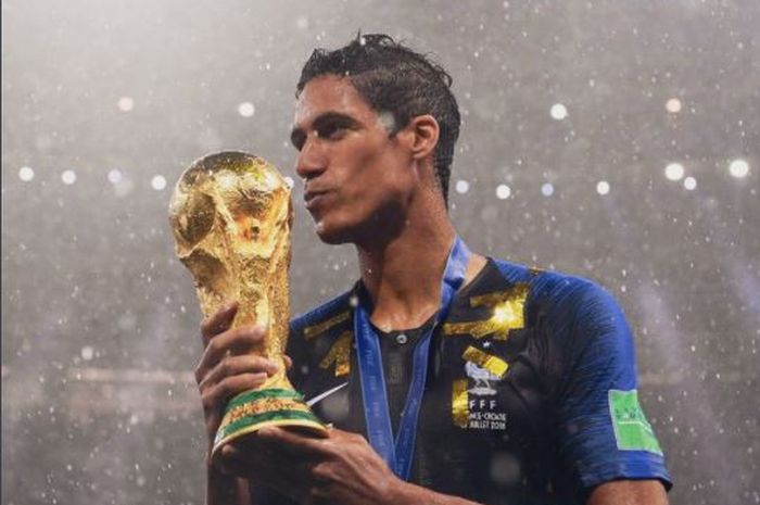 Raphael Varane mencium trofi Piala Dunia 2018 setelah juara bersama timnas Prancis.