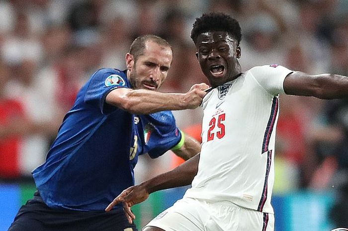 Bek timnas Italia, Giorgio Chiellini, melanggar winger timnas Inggris, Bukayo Saka, dalam laga final EURO 2020 di Stadion Wembley, Minggu (11/7/2021).