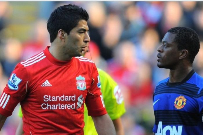Eks bek kiri Manchester United, Patrice Evra (kanan), bertatapan dengan eks striker Liverpool, Luis Suarez.