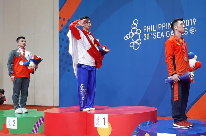 Edgar Xavier Marvelo berdiri di podium tertinggi setelah memenangkan dua emas bagi Indonesia pada cabang wushu, Selasa (3/12/2019).