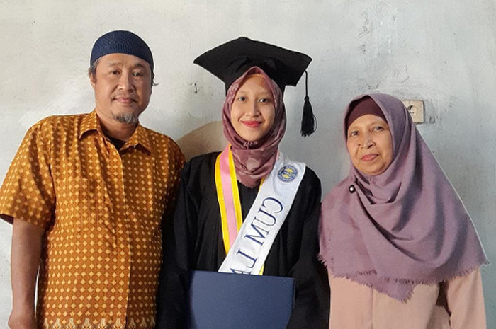 Potret wisudawan cumlaude UNY Hesti bersama orang tuanya dalam acara wisuda daring.