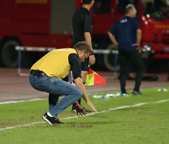 Pelatih Timnas U-23 Thailand pun ikut membantu memperbaiki kerusakan lapangan Stadion Thien Truong