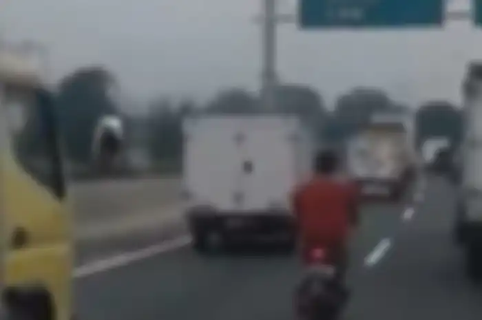 Pemotor nekat melintas di jalan tol Ancol, Jakarta Utara.