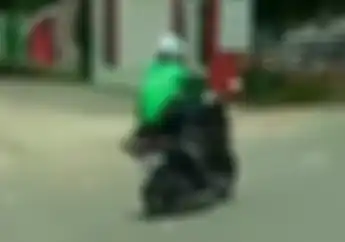 Mumpung Enggak Ada Penumpang, Abang Ojol Ini Bawa Motor Pakai Cara Paling Woles