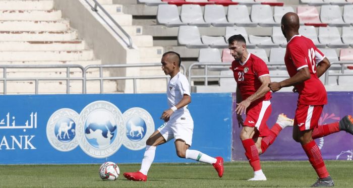 Aksi pemain timnas Indonesia, Riko Simanjuntak dibayangi bek timnas Yordania, Ehsan Haddad, di Stadion King Abdullah II, Amman, Yordania, Selasa (11/6/2019).