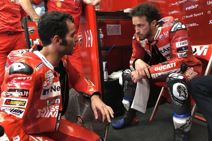 Pembalap Mission Winnow Ducati, Danilo Petrucci (kiri) dan Andrea Dovizioso (kanan) sedang berdiskusi di garasi timnya.