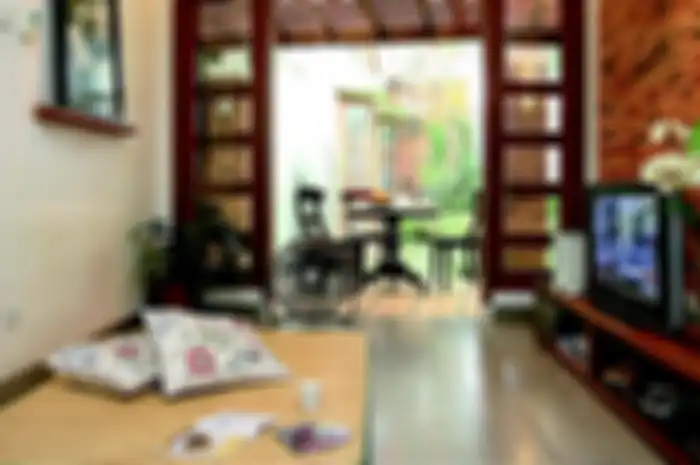 Rumah tropis alami dengan tempelan bata di dinding interiornya.