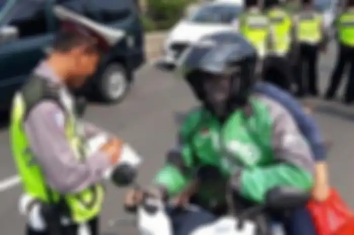 ILustrasi petugas melakukan penindakan tilang manual terhadap salah satu ojol.