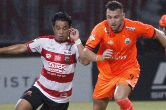 Bek sayap Madura United, Beny Wahyudi mengawal pergerakan penyerang Persija Jakarta, Marko Simic pada laga di Stadion Gelora Ratu Pamelingan, Pamekasan, Madura, Minggu (14/10/2018). (Media Persija Jakarta).