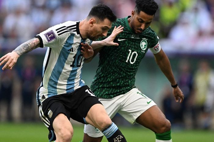 Lionel Messi (kiri) berduel dengan Salem Al-Dawsari dalam partai Piala Dunia 2022 antara timnas Argentina vs timnas Arab Saudi di Stadion Lusail, Qatar (22/11/2022).