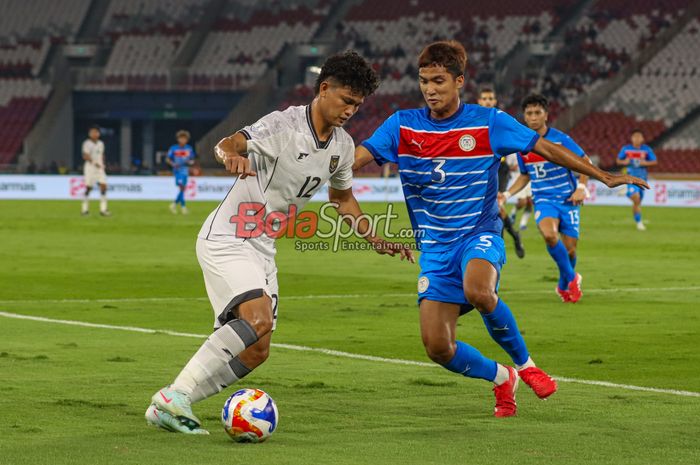 Hokky Caraka (kiri) sedang menguasai bola dan dibayangi Bryan Ezekiel Villaneuva (kanan) dalam laga babak penyisihan Grup A Piala AFF U-23 2025 antara Timnas U-23 Indonesia versus Timnas U-23 Filipina di Stadion Utama Gelora Bung Karno, Senayan, Jakarta, Jumat (18/7/2025).