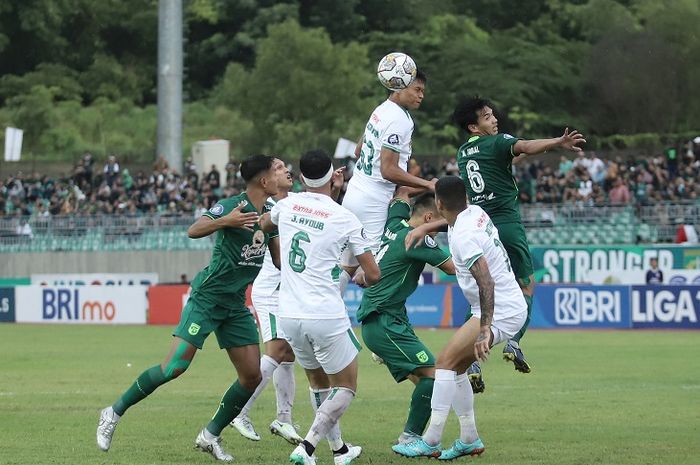 Para pemain PSS Sleman berebut bola dengan pemain Persebaya dalam laga pekan ke-24 Liga 1 2022/2023.