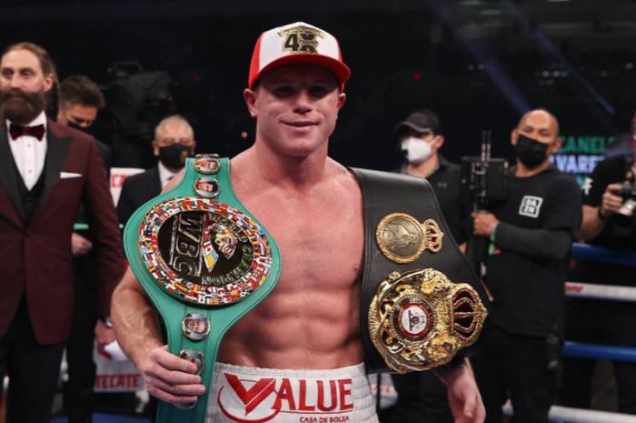 Petinju kelas menengah super, Canelo Alvarez, saat memamerkan sabuk juara WBA dan WBC.