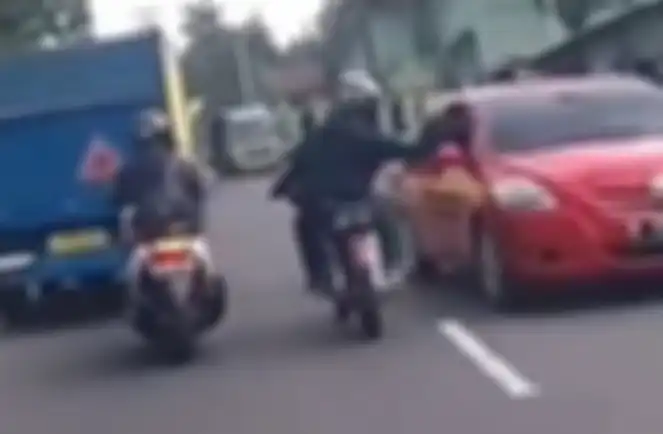 Oknum pengendara motor RX King tampar spion sedan sampai rusak.