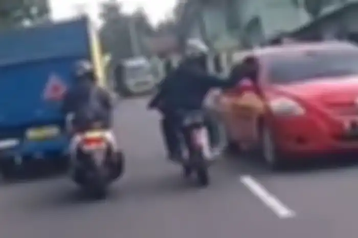 Oknum pengendara motor RX King tampar spion sedan sampai rusak.