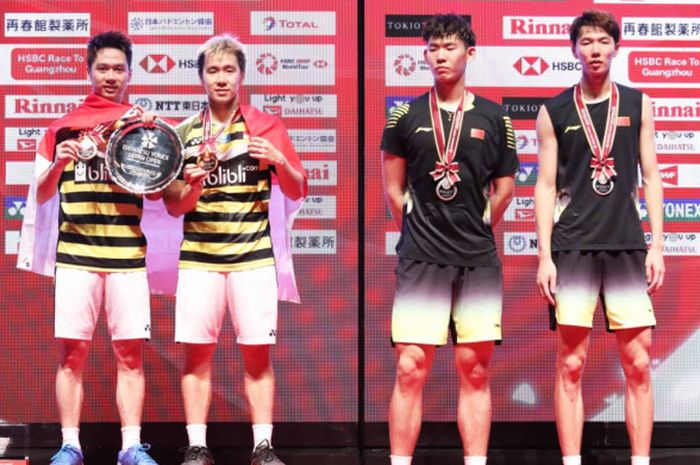 Pasangan ganda putra Indonesia, Marcus Fernaldi Gideon/Kevin Sanjaya Sukamuljo (kiri),  dan lawan mereka, Li Jun Hui/Liu Yu Chen, (China),  berpose setelah final Japan Open 2018.