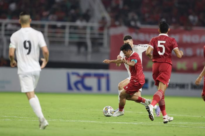 Bek timnas Indonesia Asnawi Mangkualam berduel dengan pemain Palestina.