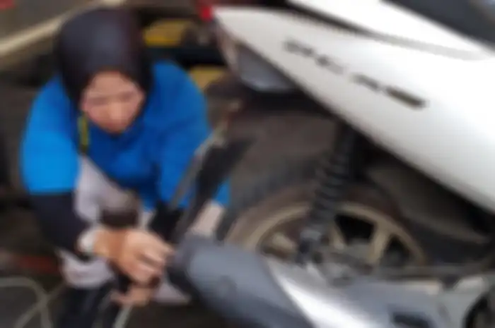 Mekanik bengkel sedang melakukan uji emisi motor