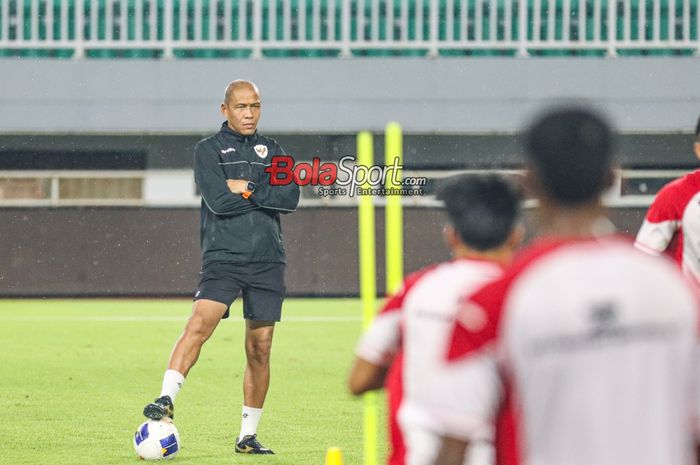 Pelatih timnas U-17 Indonesia, Nova Arianto (kiri), sedang memantau para pemainnya berlatih di Stadion Pakansari, Bogor, Jawa Barat, Kamis (13/3/2025).