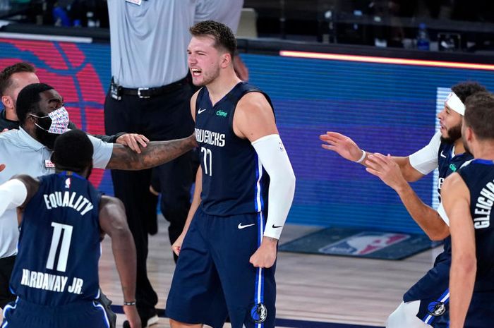 Pebasket bintang Dallas Mavericks, Luka Doncic, melakukan selebrasi bersama rekan-rekan setimnya seusai menjadi buzzer beater untuk memenangkan Mavericks atas Los Angeles Clippers, 135-133, pada perpanjangan waktu gim keempat babak kesatu playoffs NBA 2020 di Bay Lake, Florida, Amerika Serikat, Senin (24/8/2020) pagi WIB.